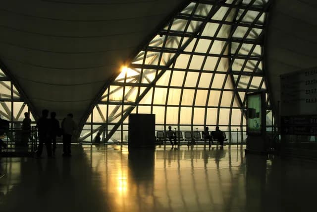 Suvarnabhumi Airport's hall at sunset, travellers in silhouette