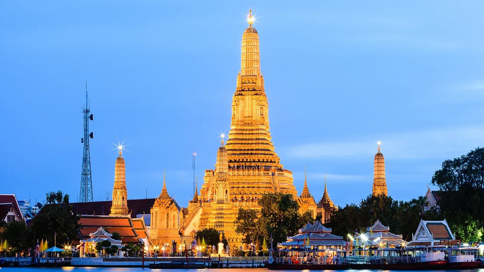 Wat Arun illuminé à l'heure bleue, au bord du Chao Phraya à Bangkok