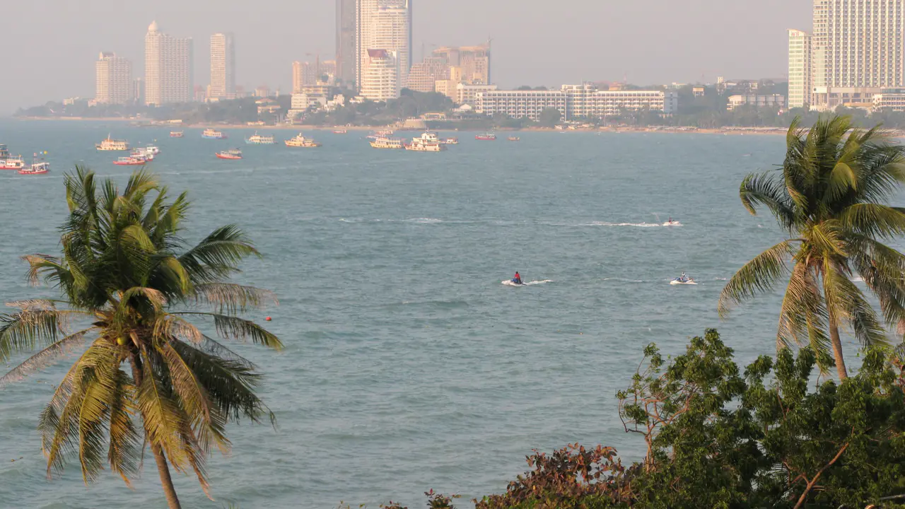 La baie de Pattaya entre deux cocotiers, avec au loin les tours du front de mer